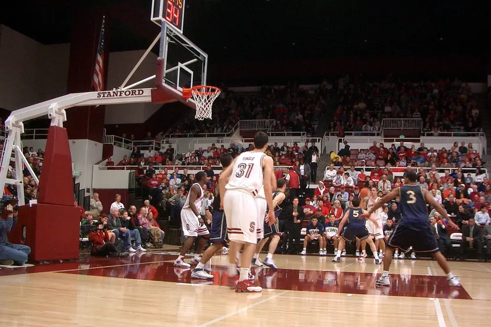 Basketball players mid-game in a packed arena