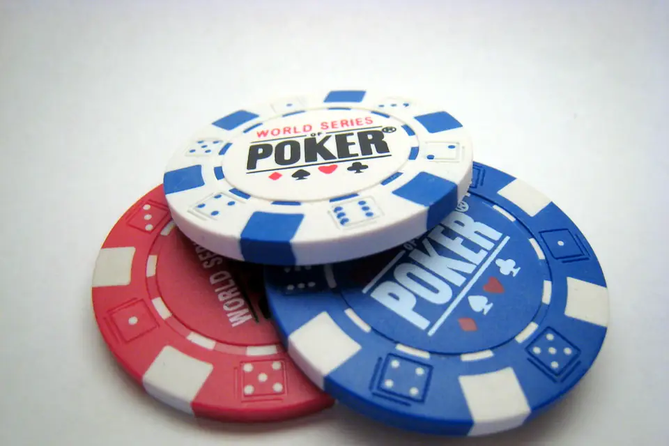 Red and blue poker chips stacked on a white table