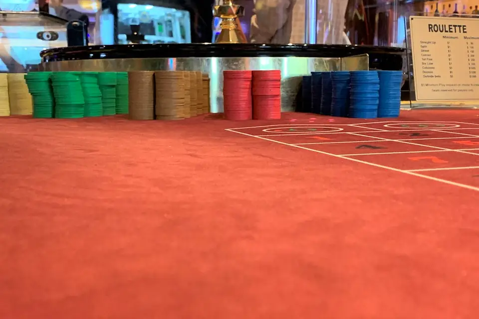 Roulette table layout on red felt with chip racks in the background