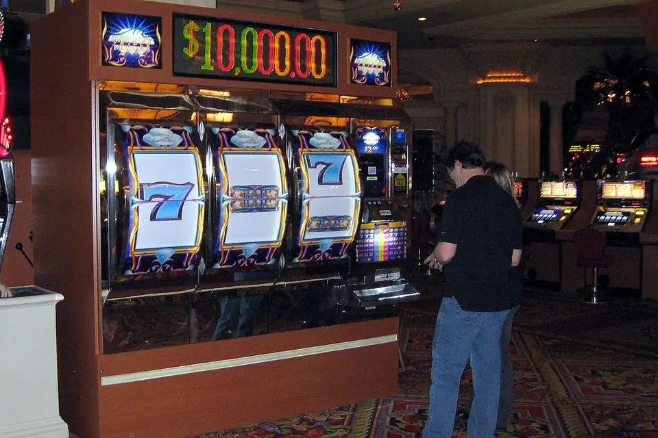 Row of illuminated slot machines on a casino floor